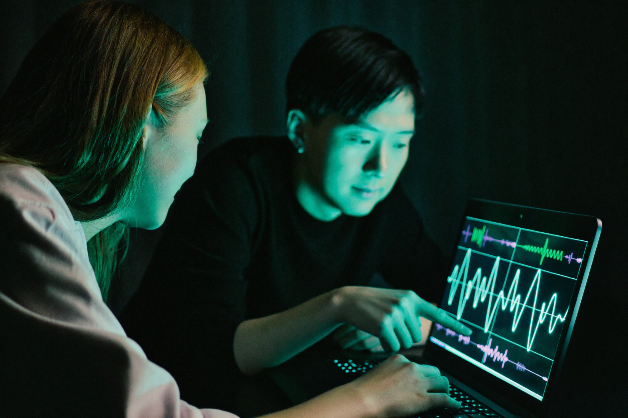Two students reading live brainwave signals on a laptop